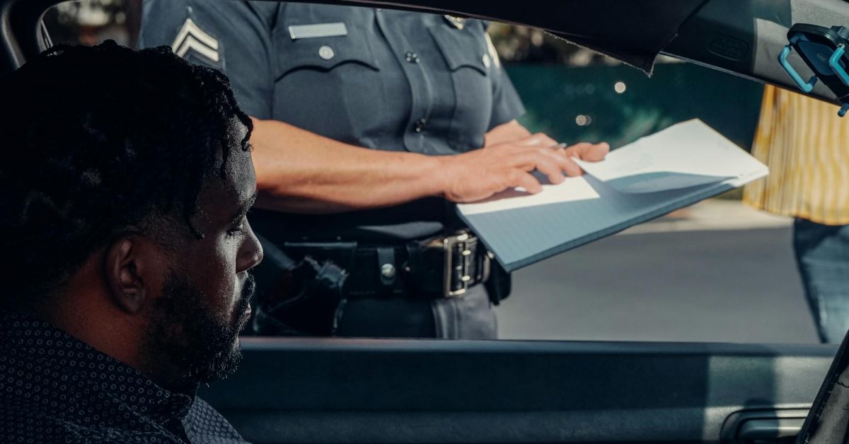 Police officer at patrol vehicle — Pennsylvania ankle monitor escape and house arrest GPS monitoring editorial context