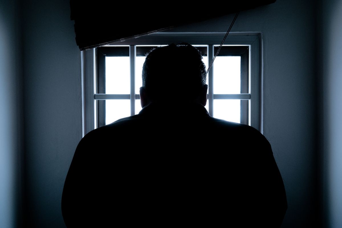Prison cell bars representing the UK prison overcrowding crisis driving electronic monitoring expansion